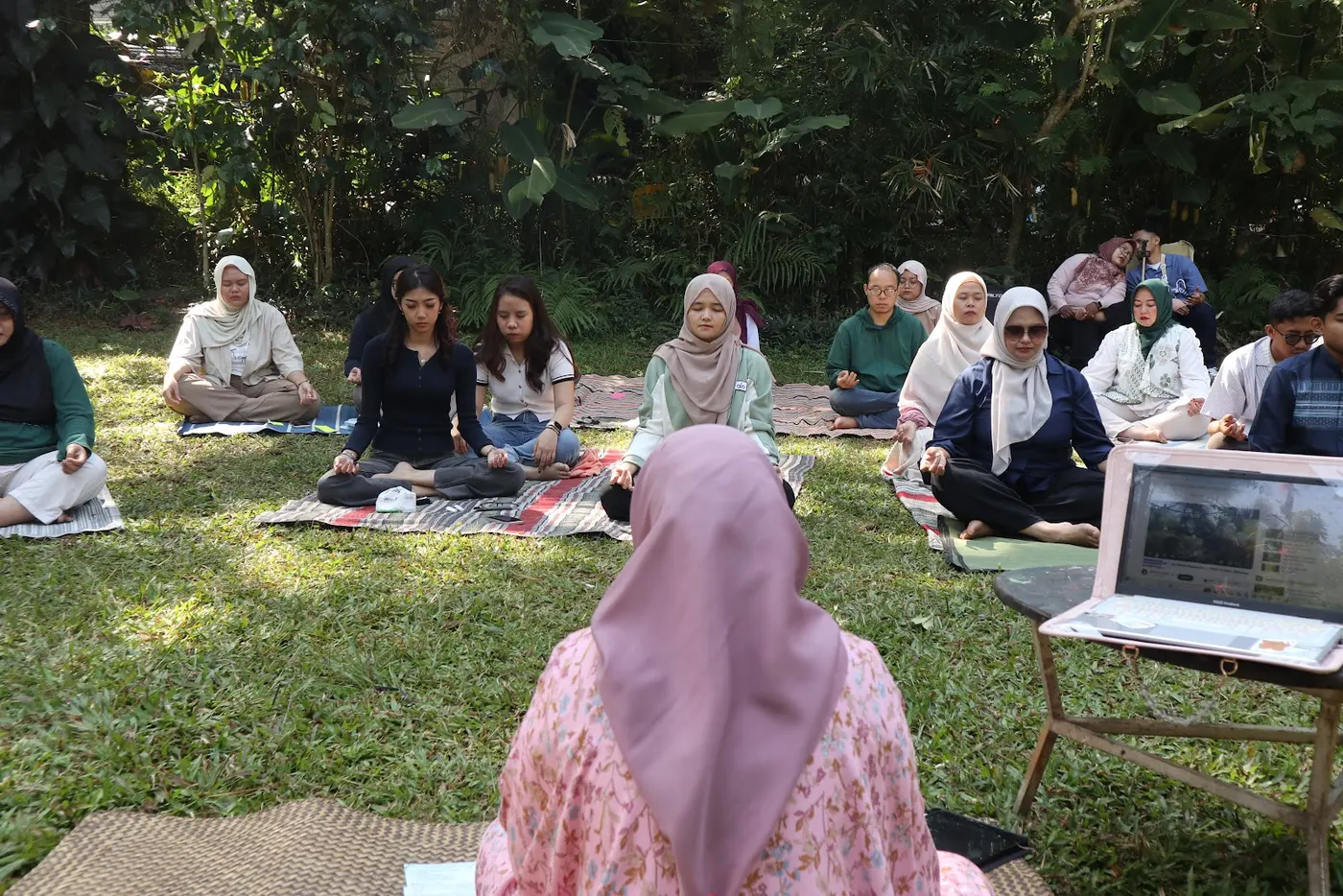 Peserta duduk melingkar di taman
